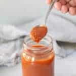 a spoonful of keto pizza sauce over a jar of sauce