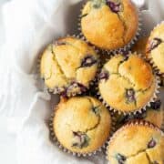 almond flour blueberry muffins in a white bowl with a white tea towel