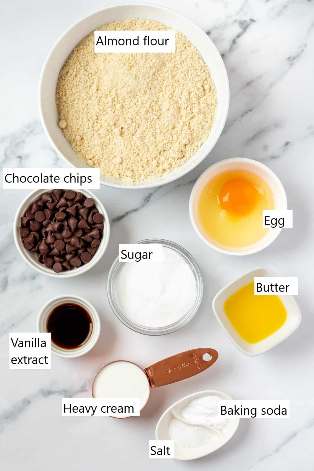 The ingredients for almond flour scones in individual bowls including egg, and chocolate chips.