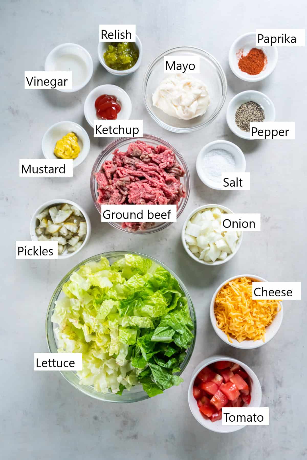 The ingredients for making a big mac salad in individual bowls.