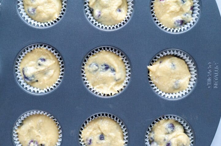 muffin pan with blueberry muffin batter ready to bake