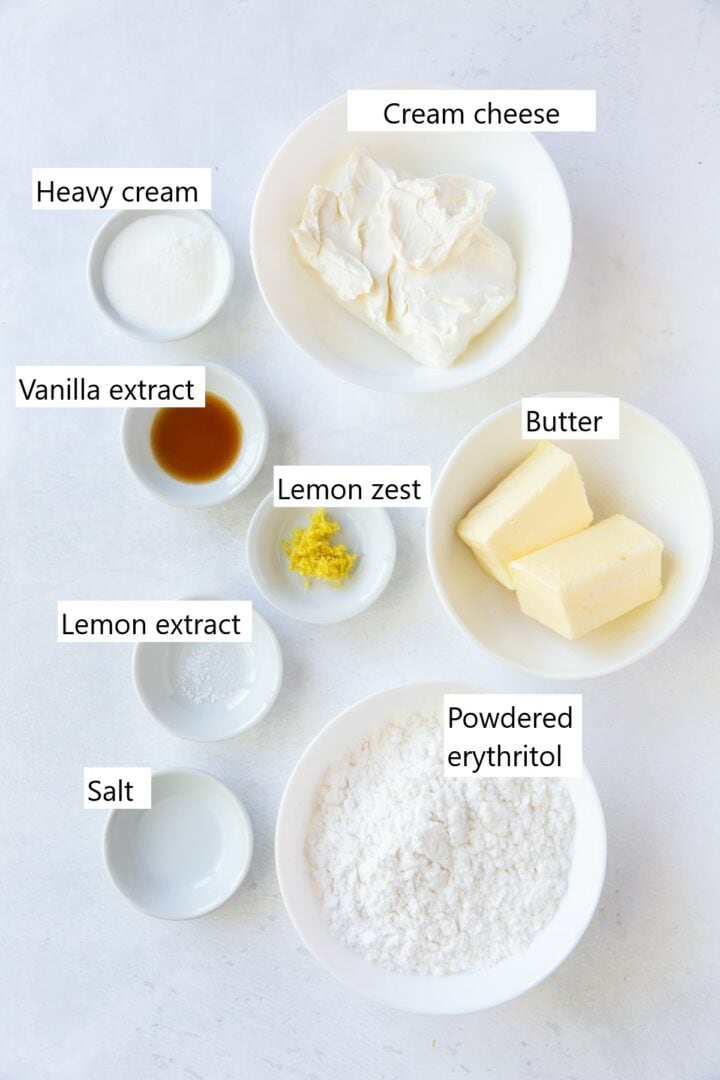 Ingredients for keto lemon cream cheese frosting in individual bowls , including butter, cream cheese, lemon zest, lemon extract and others.