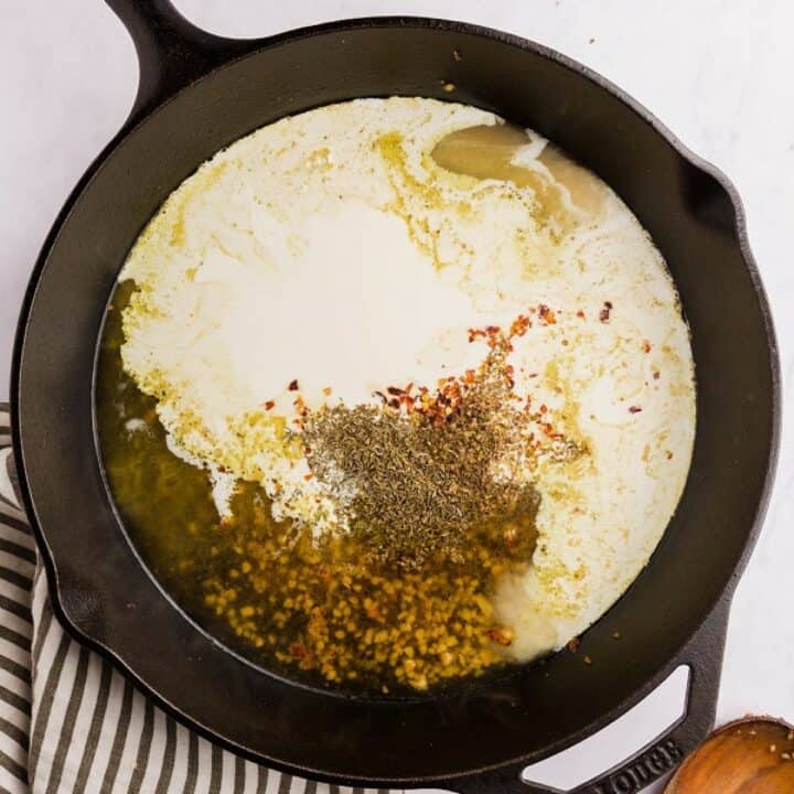 Skillet with thyme, oregano, red pepper flakes, cream and chicken broth.