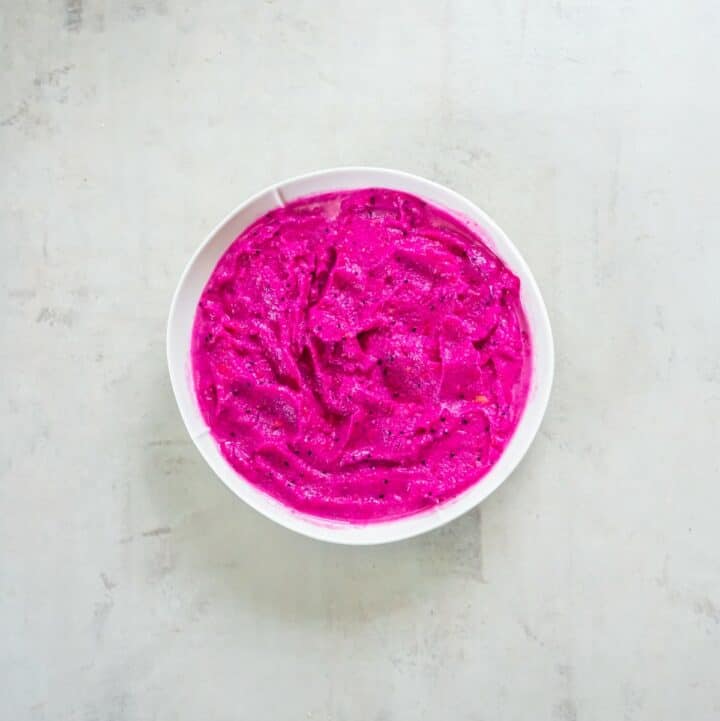 White bowl containing blended dragon fruit smoothie.
