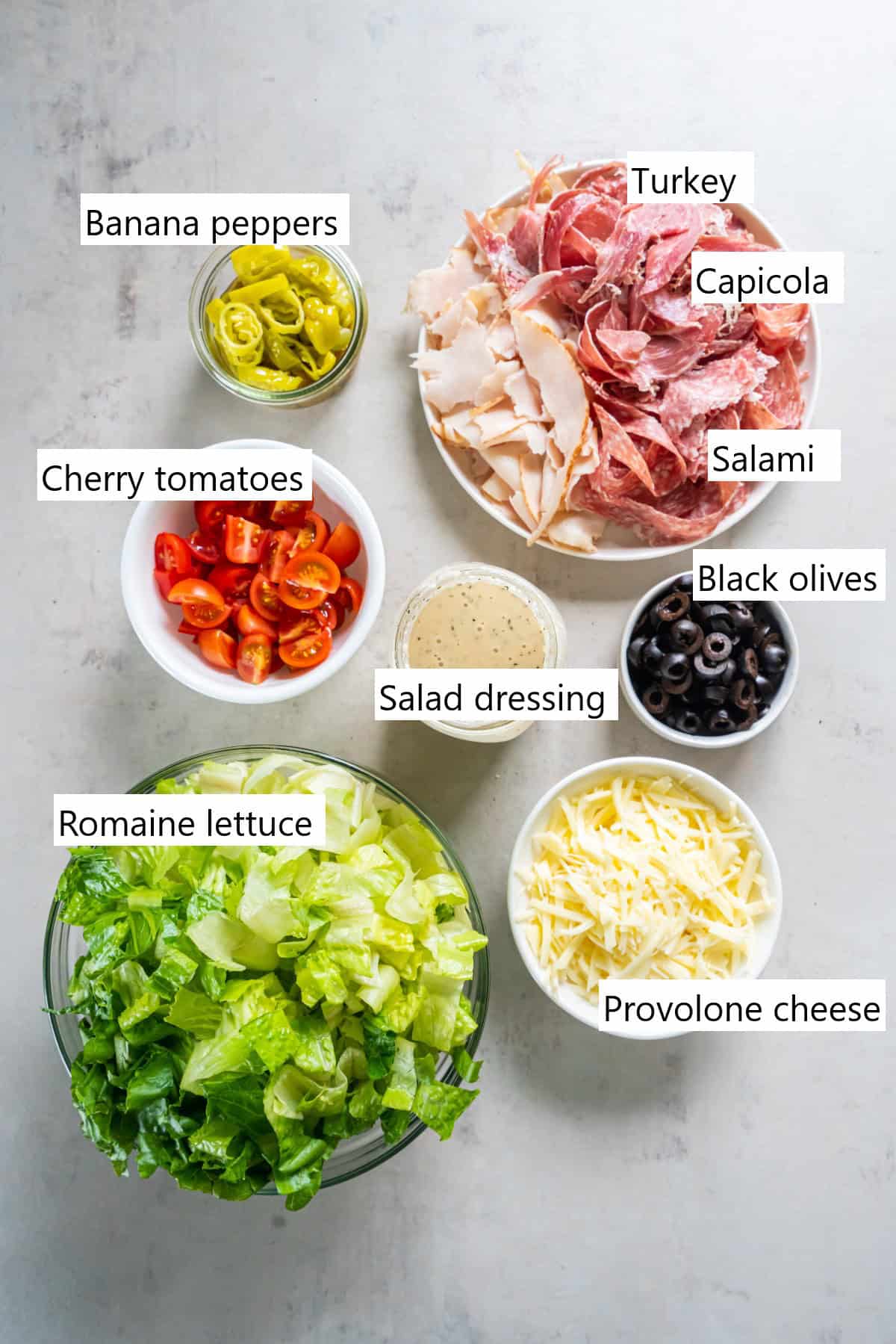 The ingredients to make a grinder salad in separate containers.
