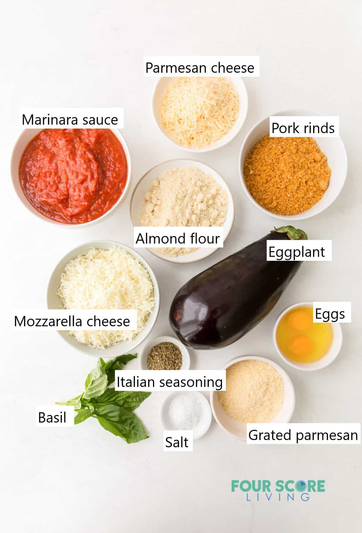 Ingredients for eggplant parmesan, including sauce, seasonings, cheeses, eggplant, and eggs.