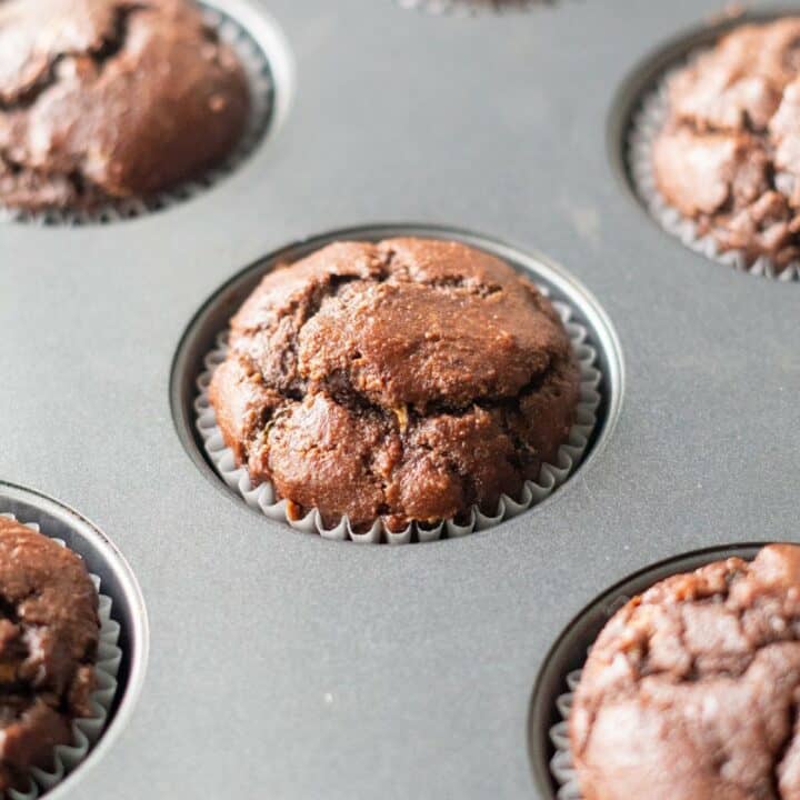 Muffin pan with fully baked keto chocolate zucchini muffins.