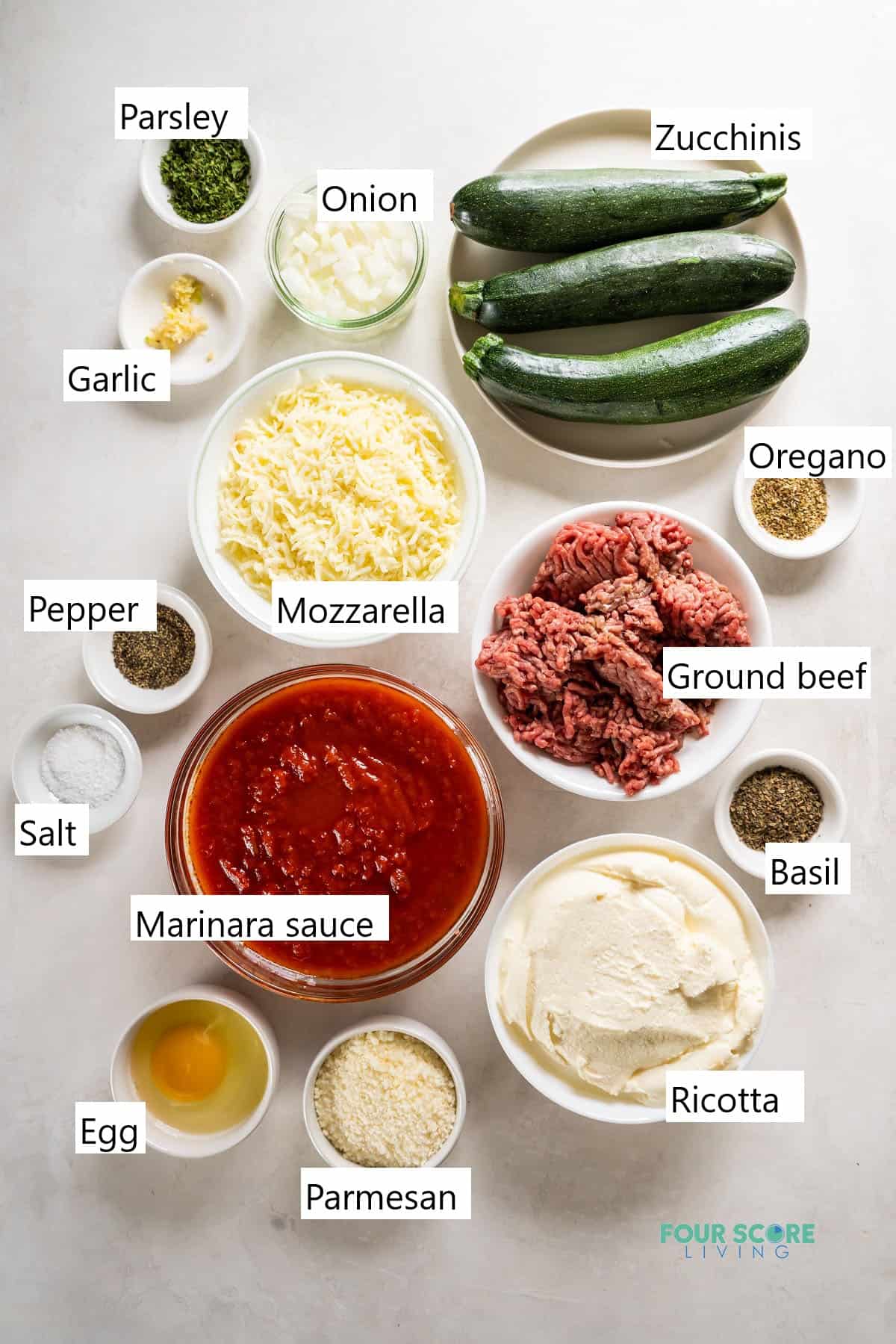 The ingredients needed to make a keto zucchini lasagna, all measured into small bowls.