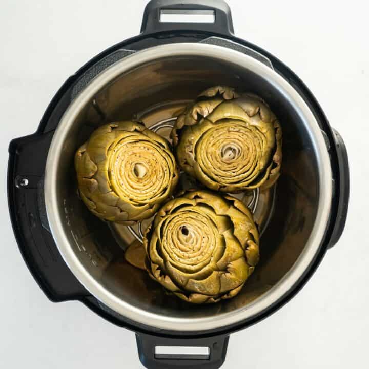 Three fully cooked artichokes in an instant pot.