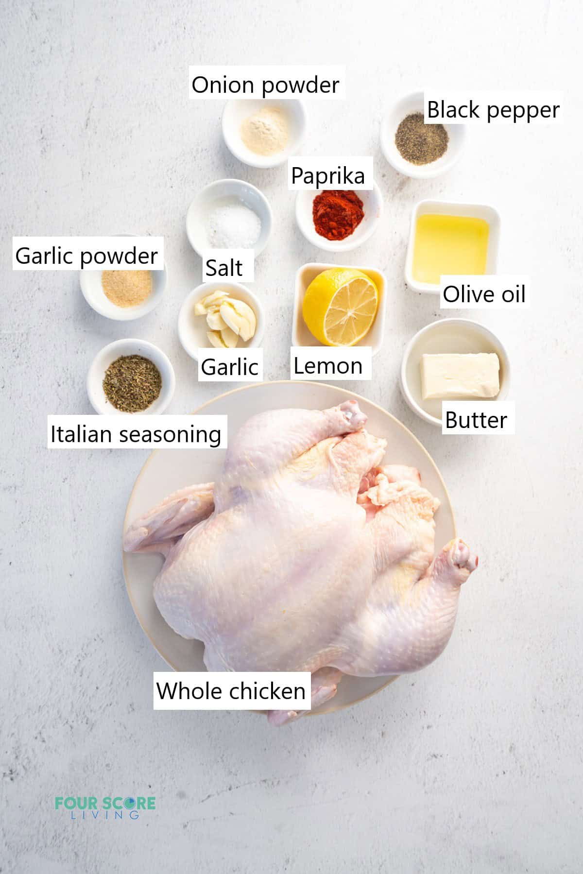 Ingredients for making a whole chicken in the instant pot in separate bowls. Includes a whole chicken, lemon, butter, garlic, and seasonings.