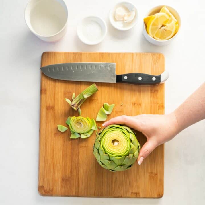 Top third of an artichoke has been cut off, exposing the inside.