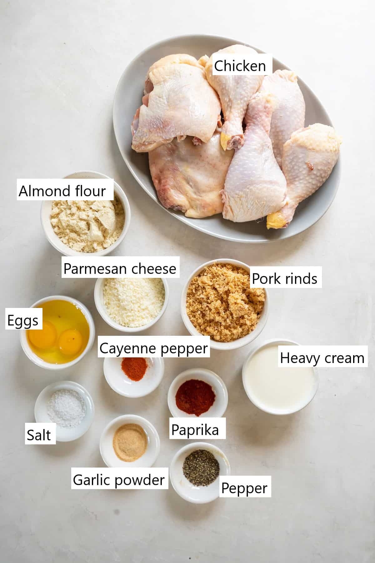 The ingredients needed to make crispy keto fried chicken, all the seasonings are measured into separate small bowls.