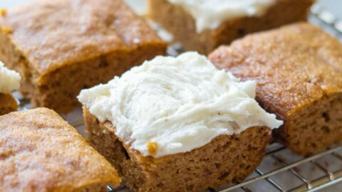 keto pumpkin bars on a wire rack with frosting.