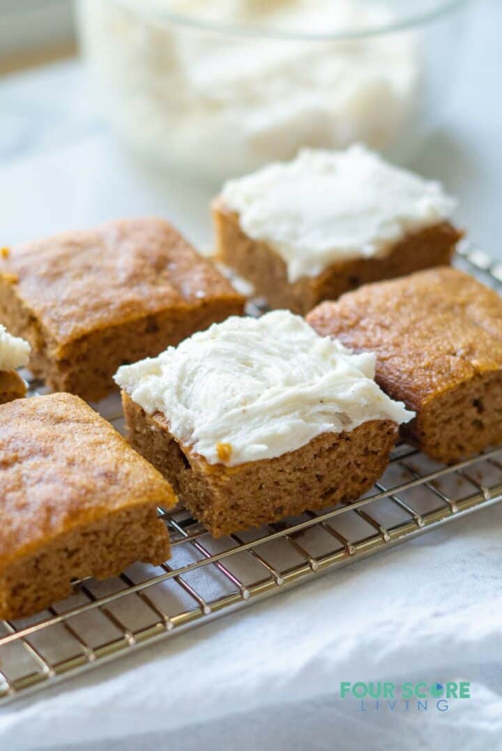 keto pumpkin bars on a wire rack with frosting.