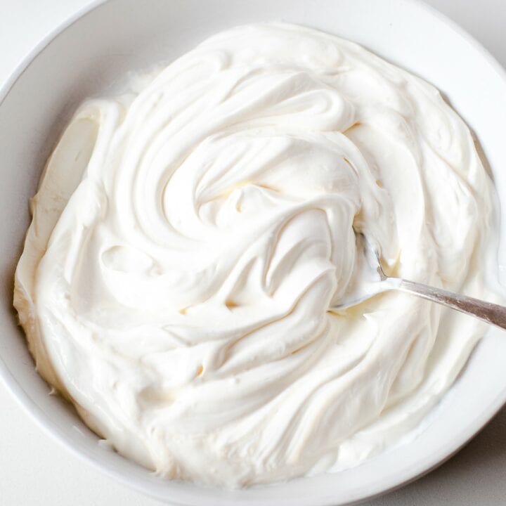 Bowl with mayonnaise and sour cream being mixed together.