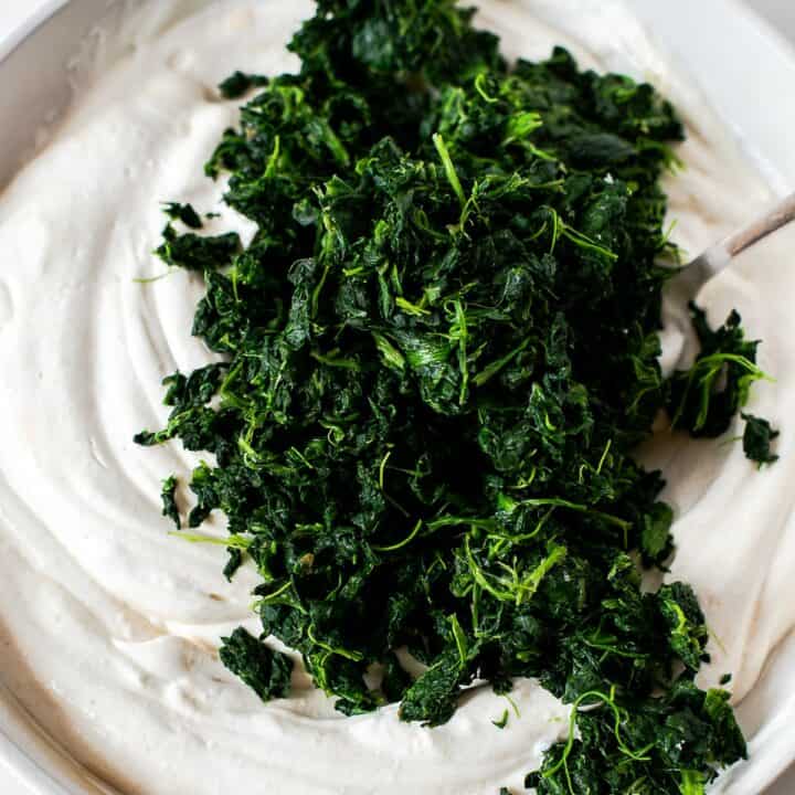 Spinach being added to the mixture.