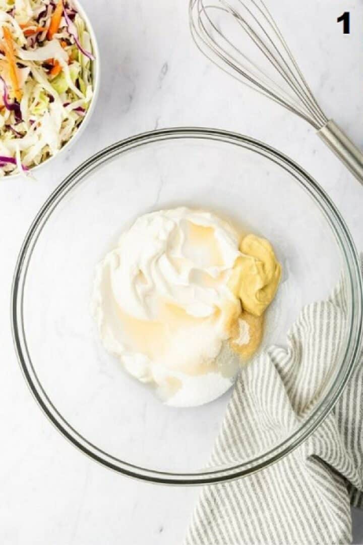 Glass bowl with the unmixed dressing ingredients.