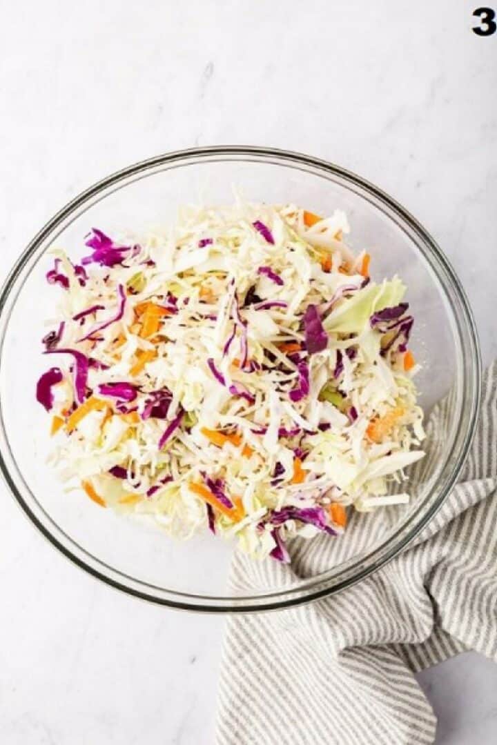 Shredded coleslaw mix in a glass bowl.