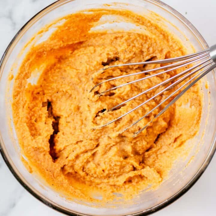 Glass bowl with low carb pumpkin muffin batter being mixed.