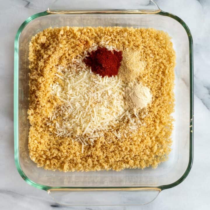 Glass dish with pork rinds, parmesan cheese and seasonings.