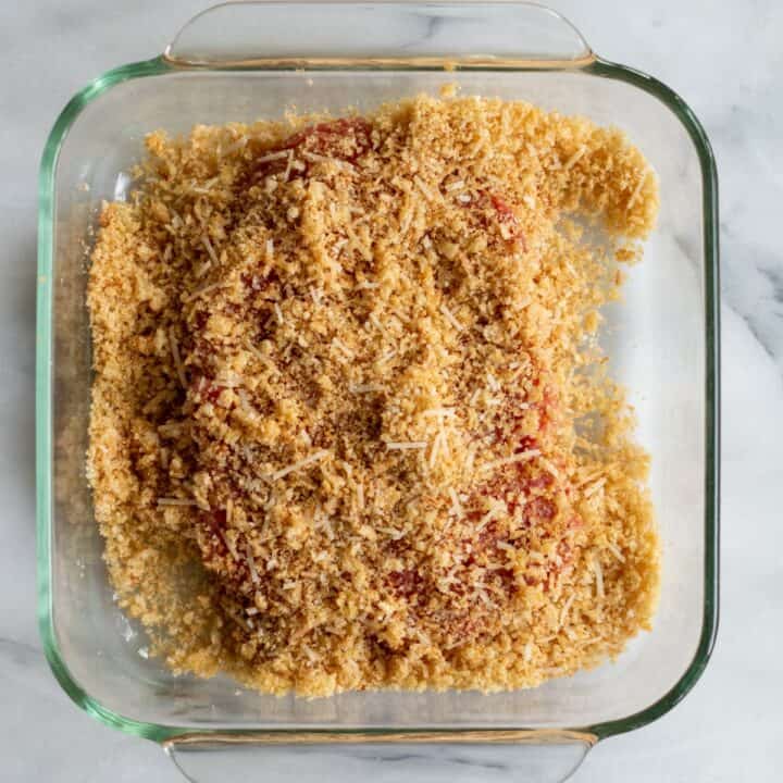 Dish with cube steak being coated in pork rind breadcrumbs.