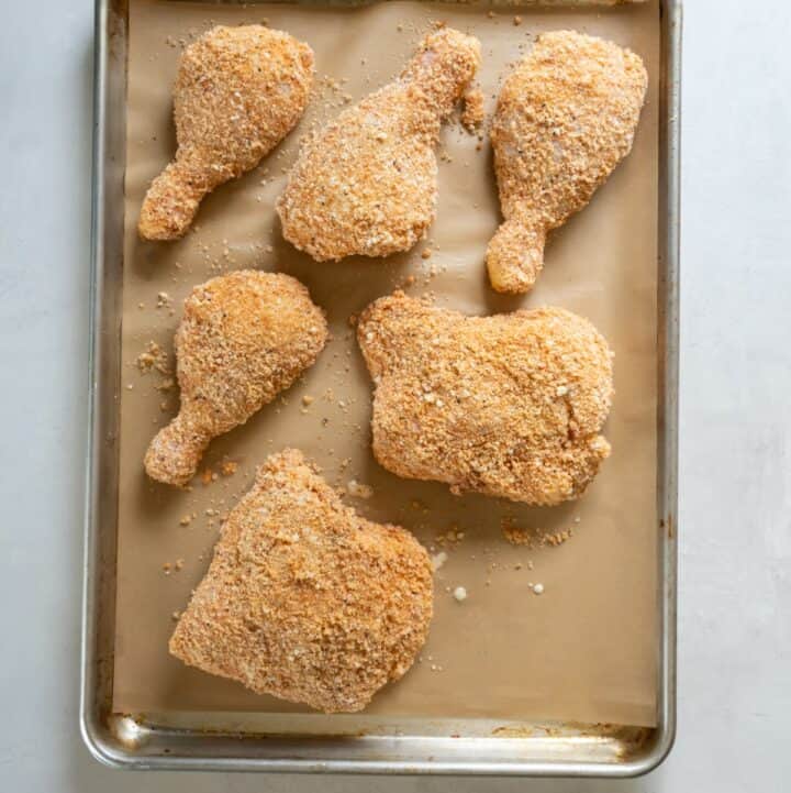 Fully dredged chicken on a baking sheet ready to be fried.