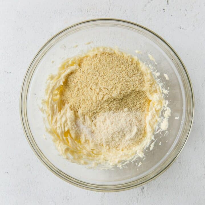 Glass bowl with flour and salt being added to the butter and erythritol mixture.