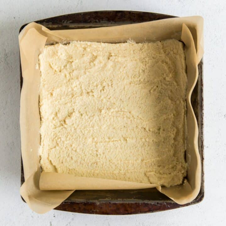 Lemon bars crust pressed evenly into a prepared cake pan.