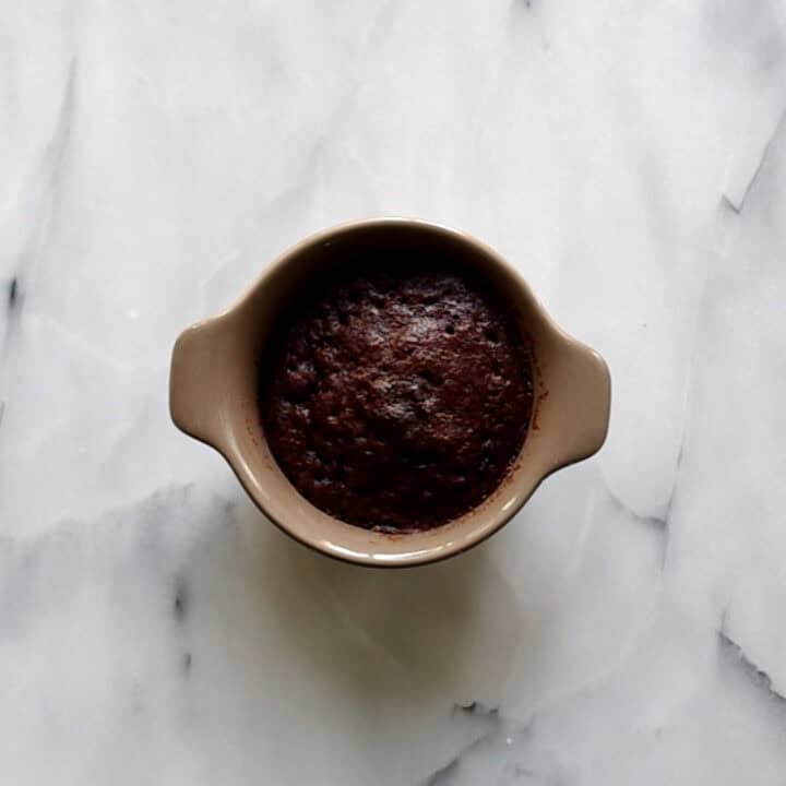 A fully microwaved keto chocolate mug cake ready to eat.