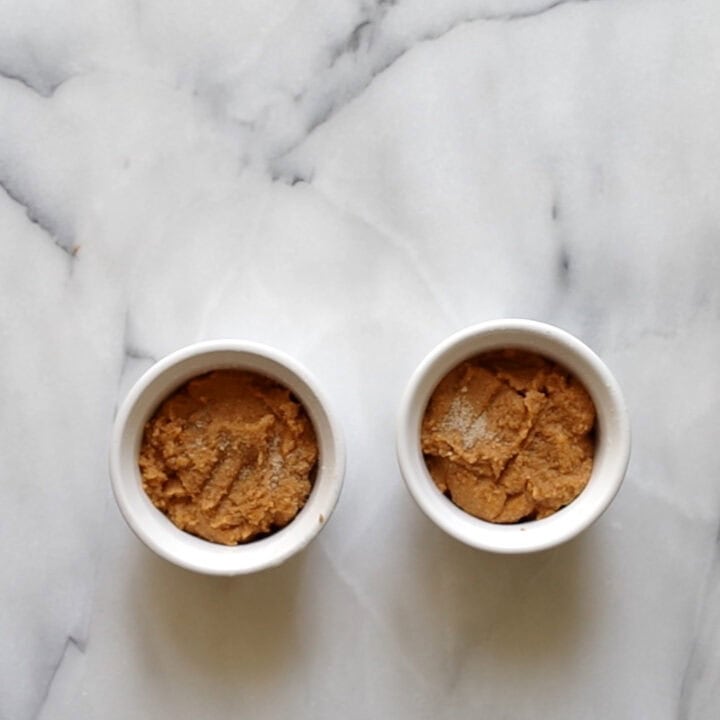 The keto pumpkin mug cake batter in two ramekins ready to be microwaved.