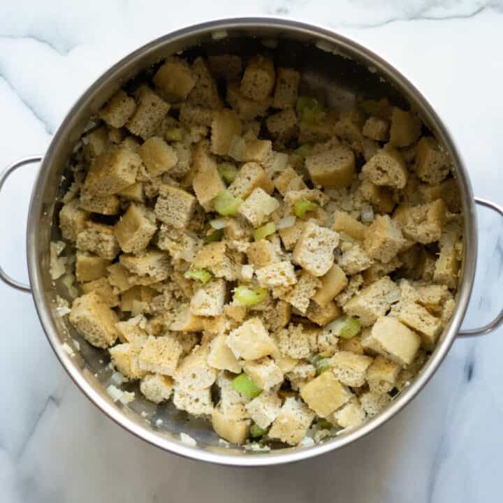 Pot with keto stuffing bread mixed into the seasoned cooked onions and celery.