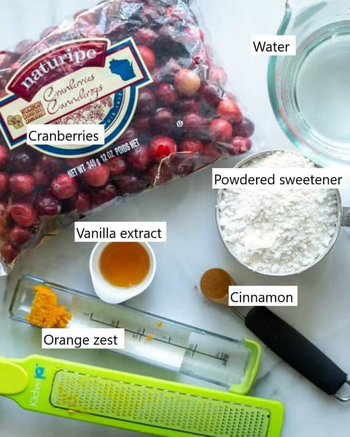 The ingredients needed to make our keto cranberry sauce recipe. Cranberries, orange zest, cinnamon, vanilla extract, water and powdered sweetener.