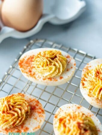 keto deviled eggs on a wire rack with paprika sprinkled on top.