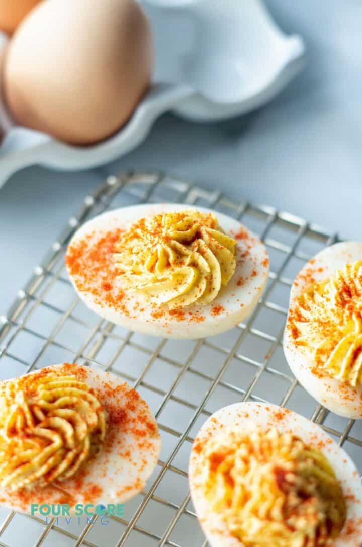 keto deviled eggs on a wire rack with paprika sprinkled on top.