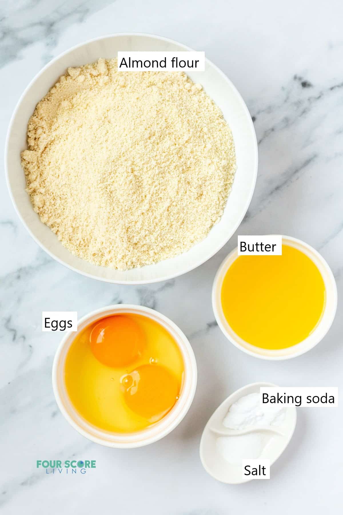 Ingredients needed to make almond flour biscuits in individual bowls.