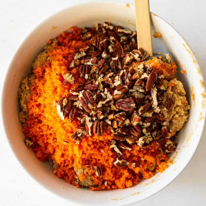 The shredded carrots and nuts being added to the carrot cake batter.