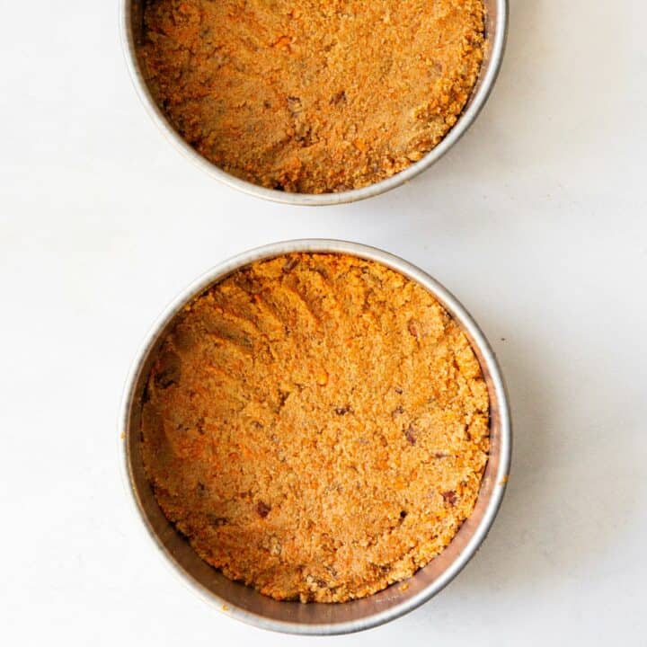 Two cake pans, each filled with half of the keto carrot cake batter.