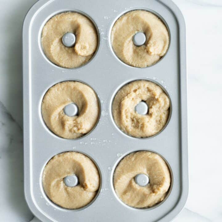 A donut pan with six keto donuts ready to be baked.