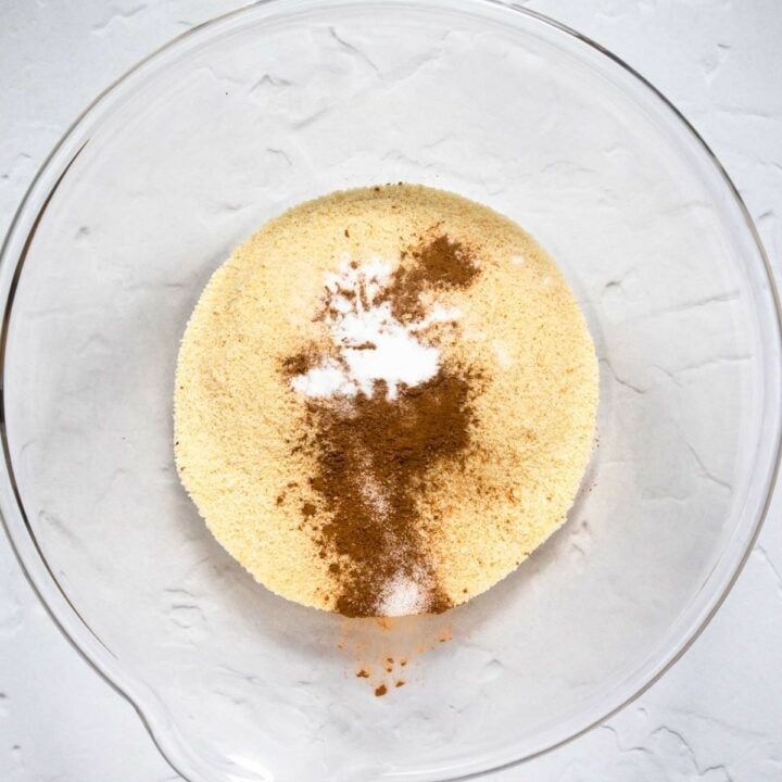 Glass bowl with the dry ingredients of almond flour, salt, baking soda and cinnamon.