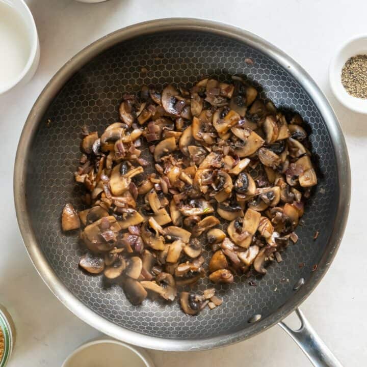 Mushrooms, garlic and onions being sauteed in a skillet.