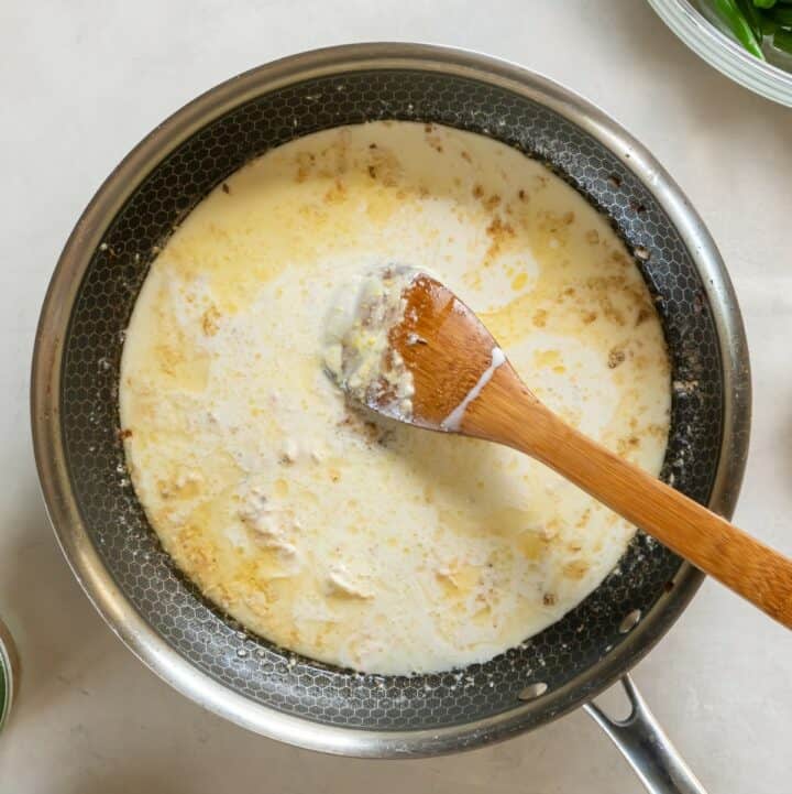 Butter, chicken broth, cream, cream cheese and dijon mustard simmering in a skillet.