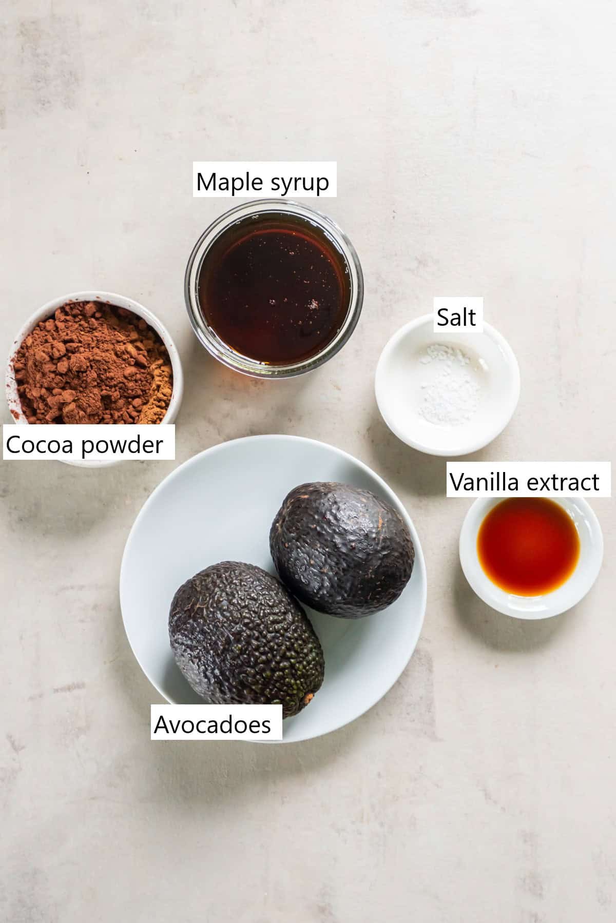 Ingredients needed to make avocado chocolate pudding, all in individual bowls.