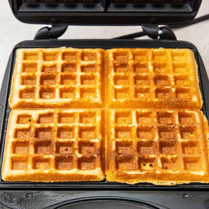 A waffle iron with 4 fully cooked keto waffles.